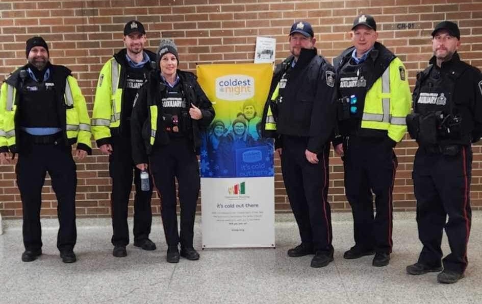 Six members of the Auxiliary Unit with a Coldest Night of the Year Banner